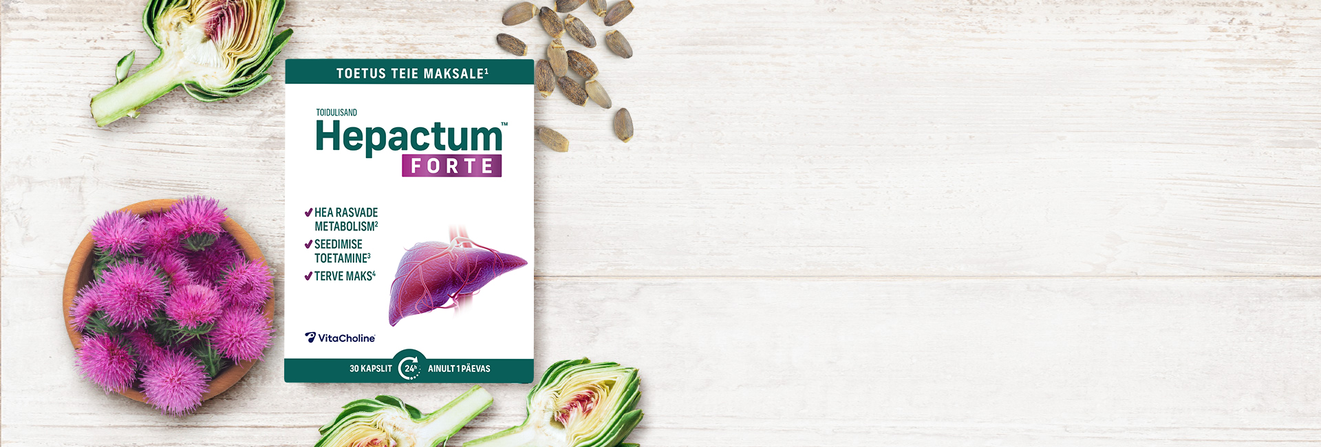 Natural Pharmaceuticals Hepactum&trade; FORTE Hepactum FORTE toidulisandi pakend on paigutatud keset heledat puidust tausta. Pakendi ümber on taimseid koostisosi: artišokid (pooleks lõigatud), piimjuure seemned ja lillad piimjuure õied kausis.